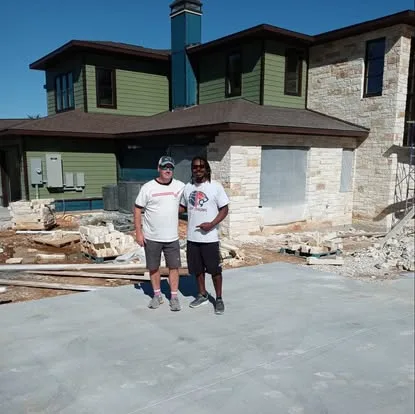 Two men standing outside a house under construction