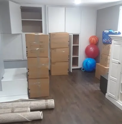 Packed boxes and rolled rugs in a room