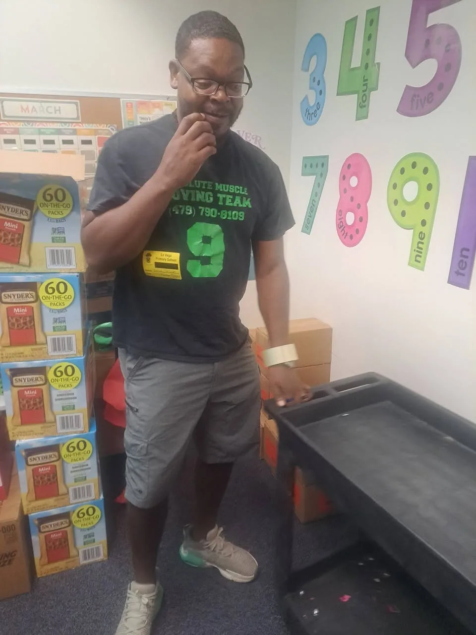 Moving team member beside a cart and stacked boxes