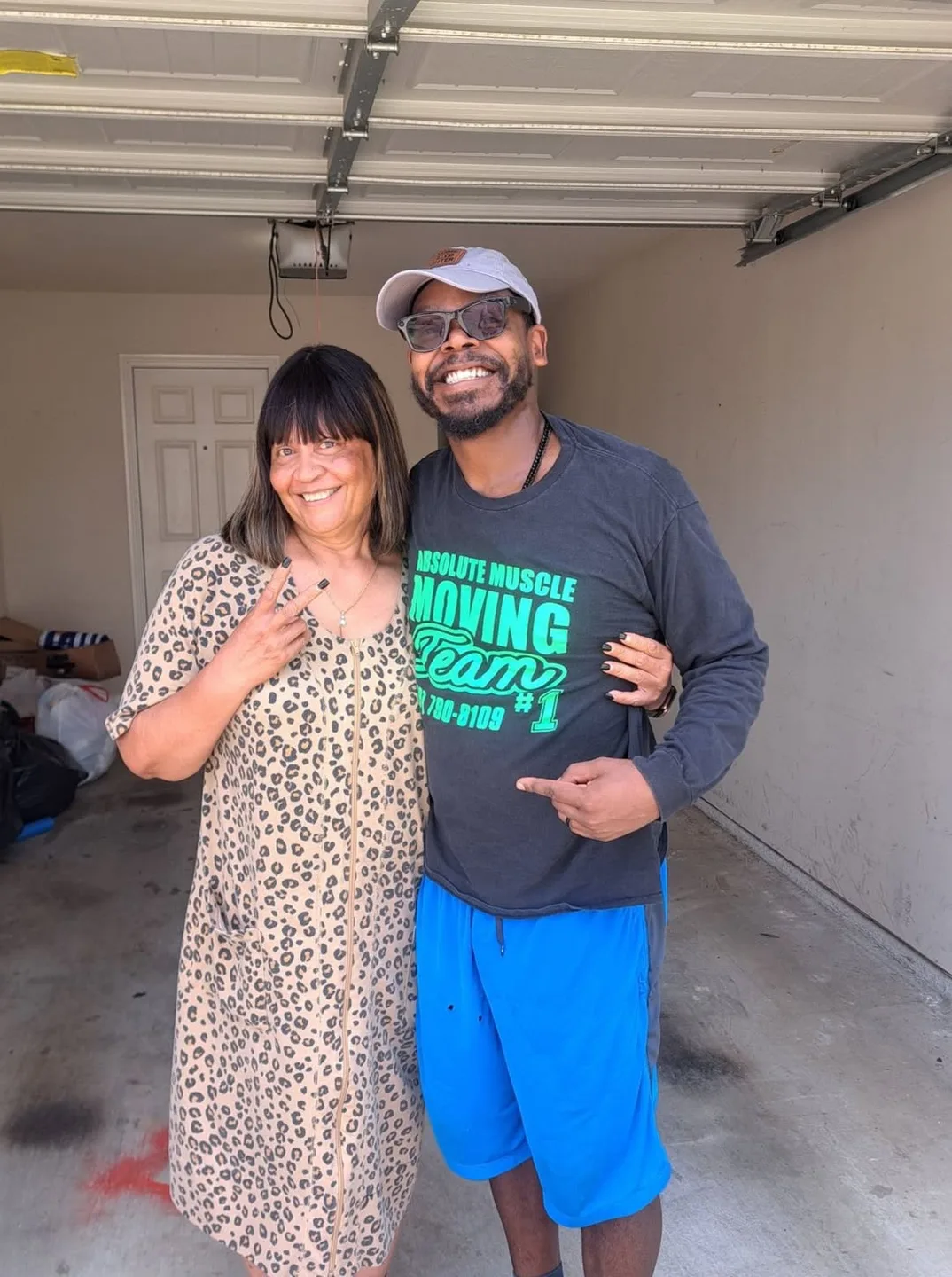 Moving team member and a woman smiling in a garage