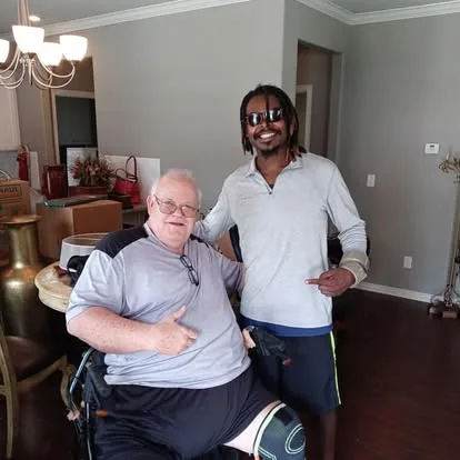 Moving team member beside a seated man indoors