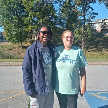 Moving team member and a woman standing outdoors